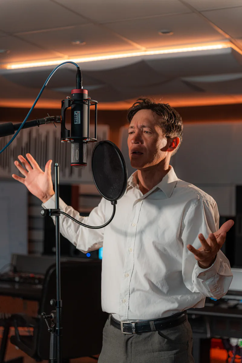 Zirano singing into the studio microphone