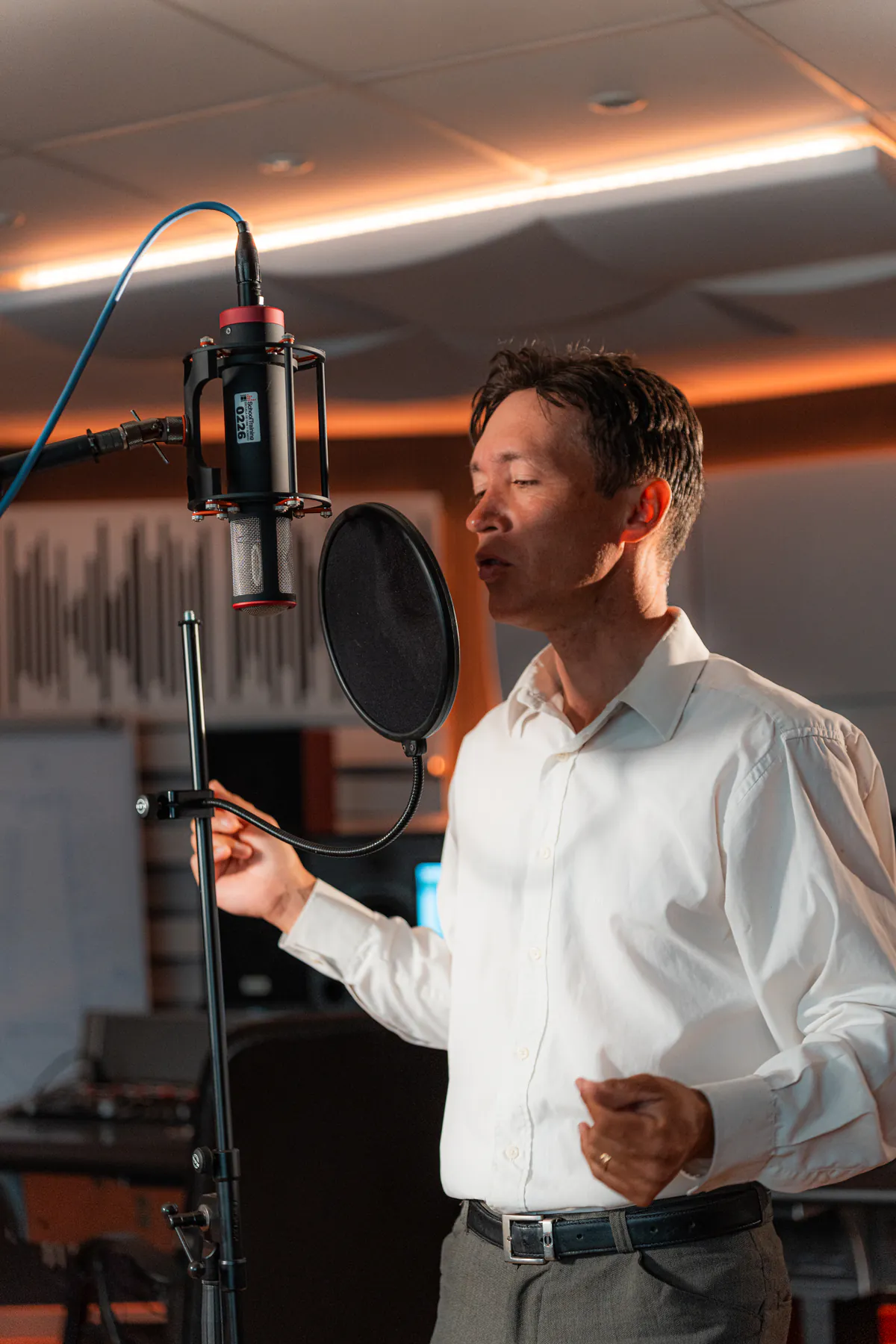 Zirano singing in profile into a microphone