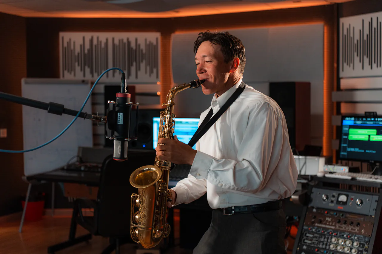 Zirano recording the saxophone in front of the studio microphone