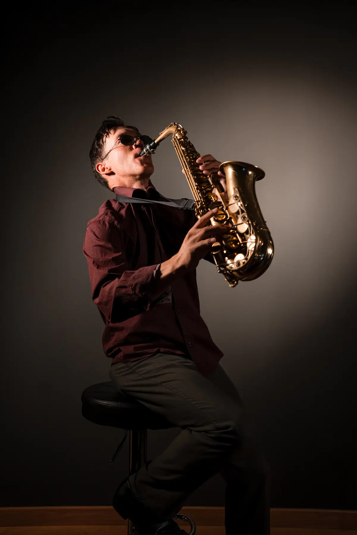 Zirano tocando el saxofón echado hacia atrás, con gafas de sol