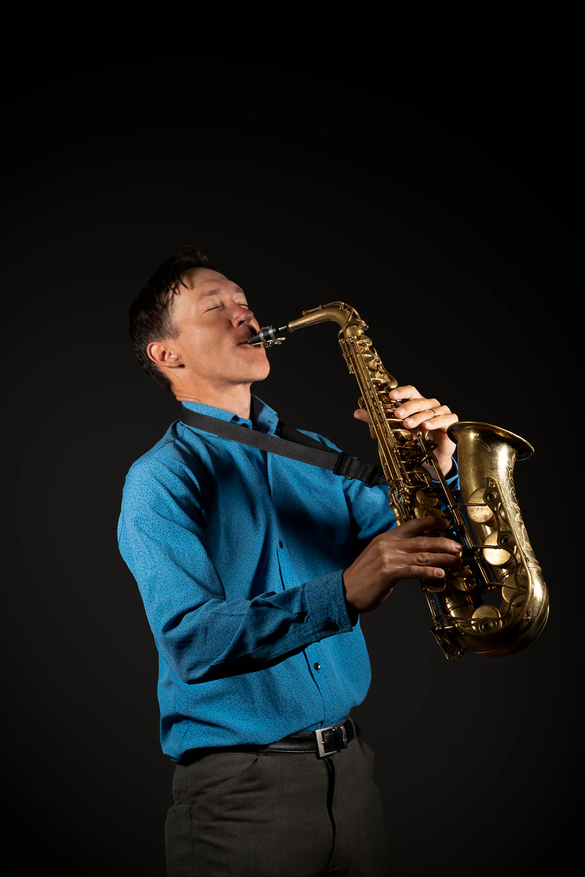 Zirano tocando el saxofón alto con camisa azul