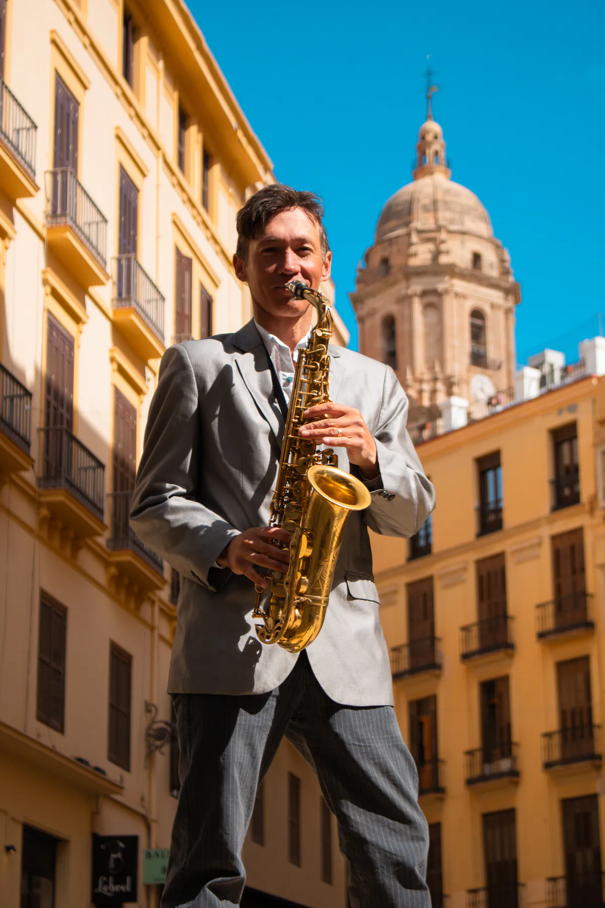 Zirano tocando el saxofón con la catedral de Málaga detrás