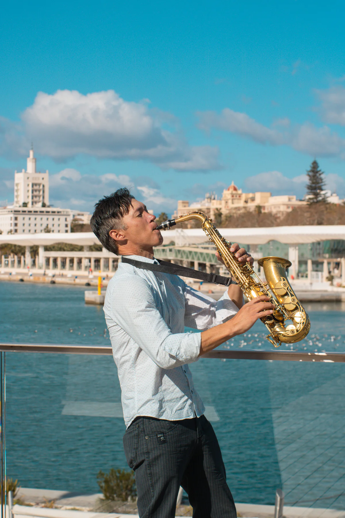 Zirano tocando el saxofón frente al puerto de Málaga