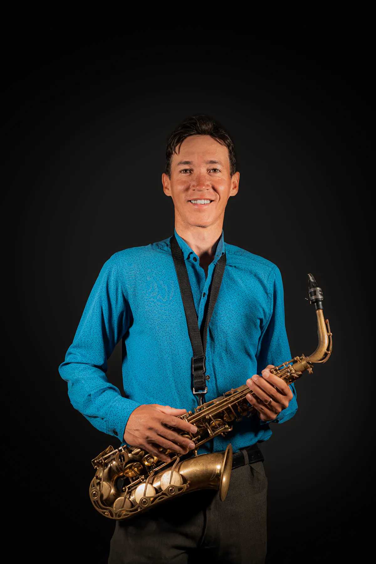 Zirano sonriendo con su saxofón alto sobre fondo negro