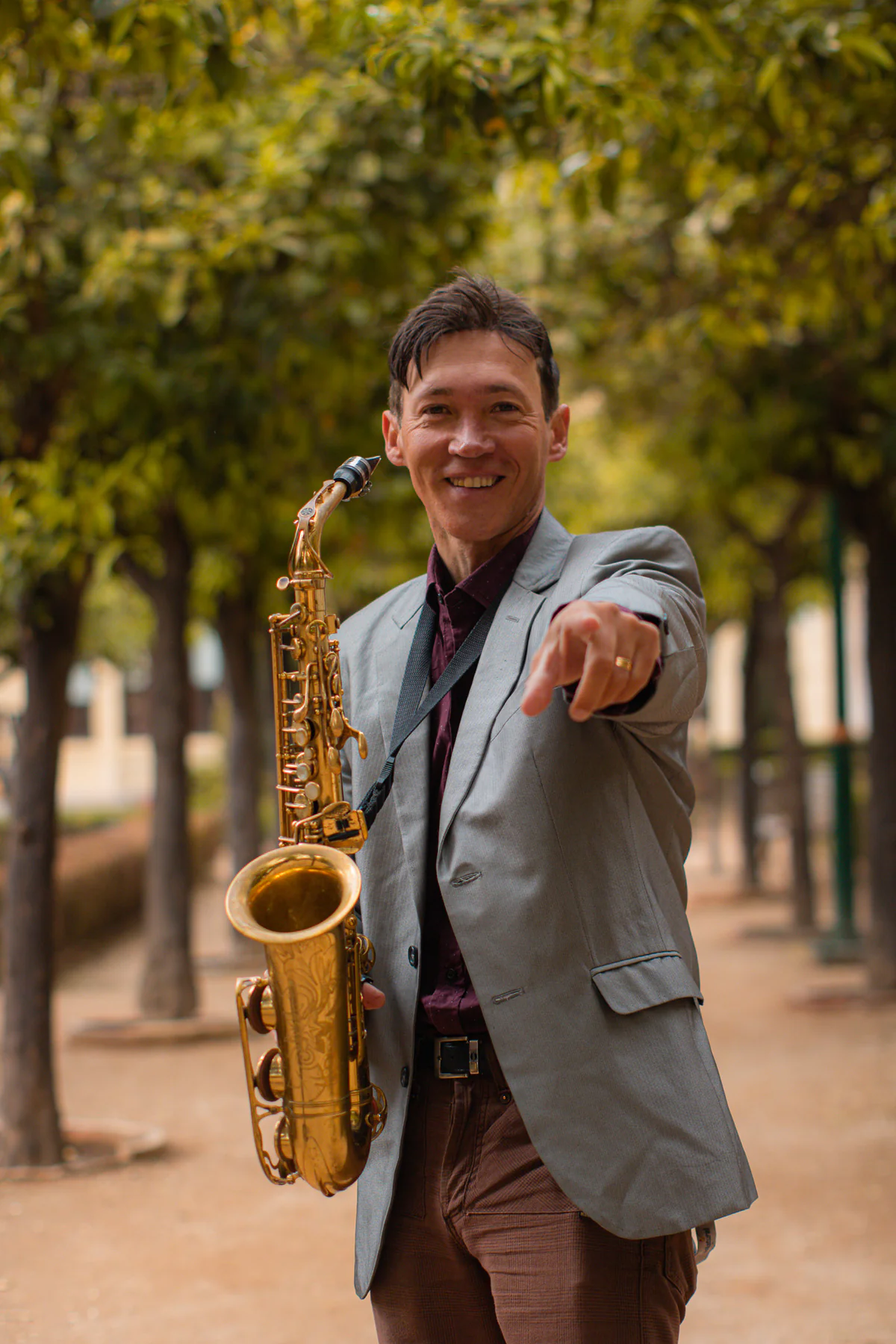 Zirano sonriendo y señalando a cámara con el saxofón