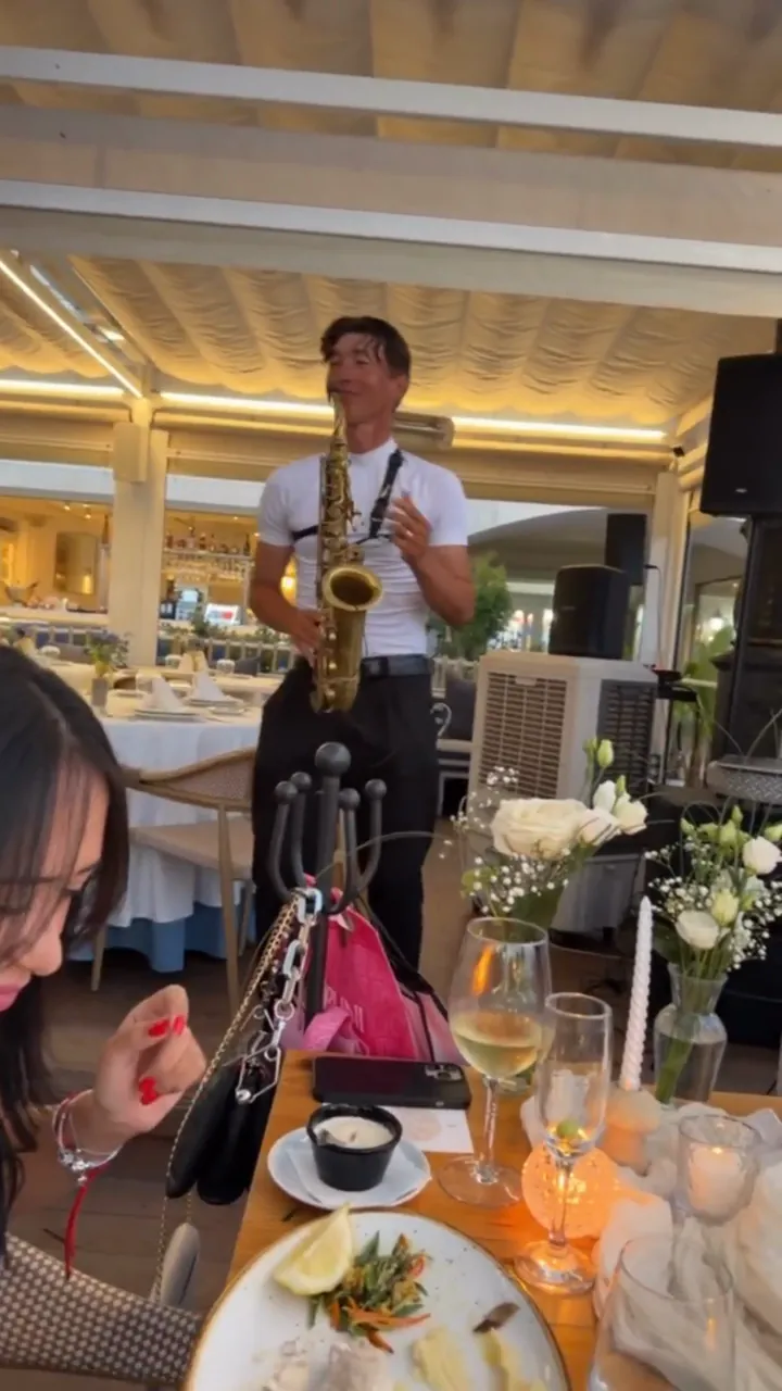 Zirano tocando el saxofón entre mesas puestas durante una boda