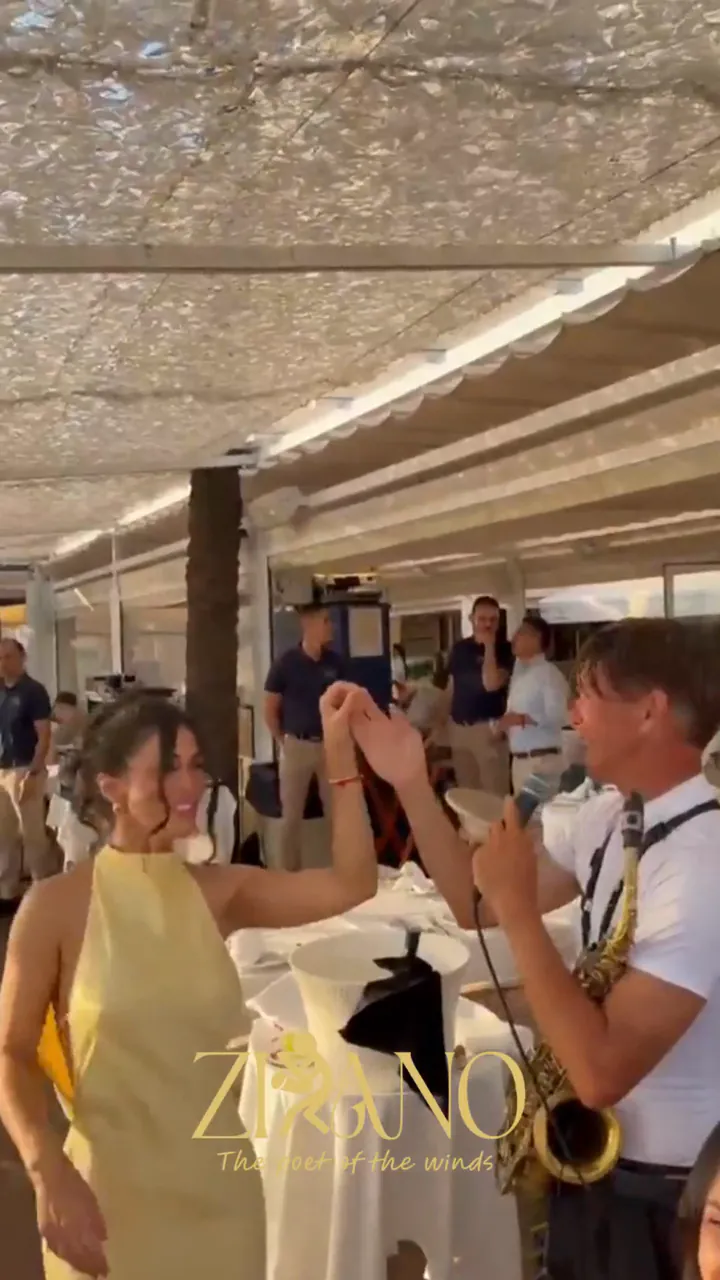 Invitados bailando con Zirano en la terraza de un restaurante durante un cumpleaños