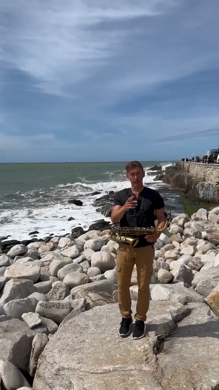 Zirano con el saxofón en unas rocas junto al mar, hablando a cámara