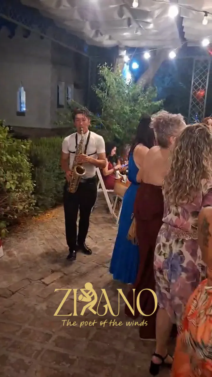 Zirano tocando el saxofón de noche entre los invitados